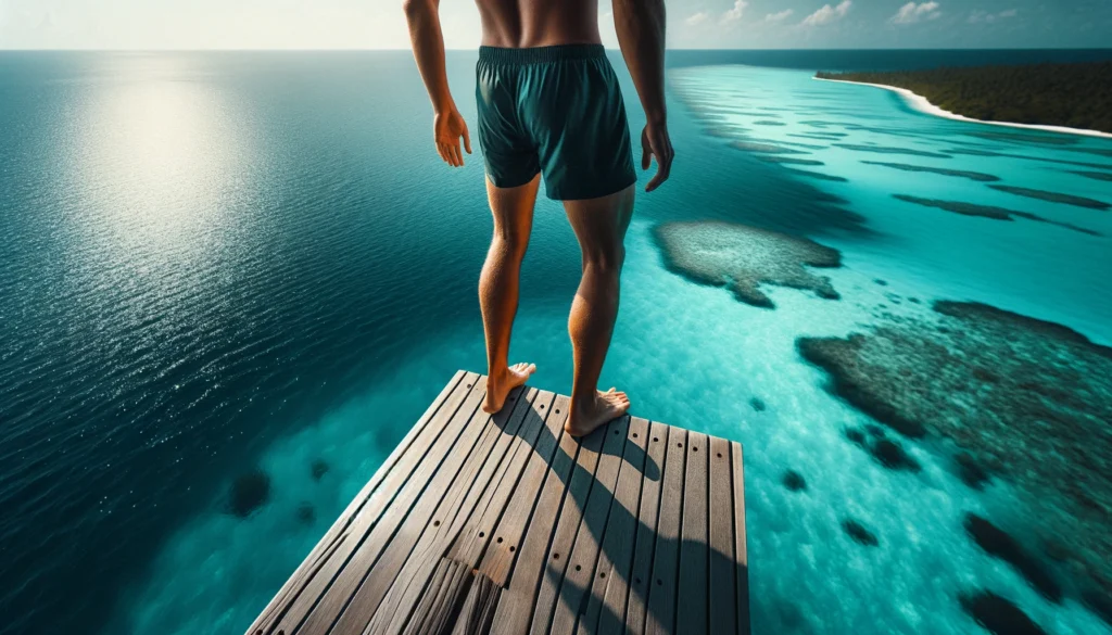 Exploring Salagdoong: Siquijor's Man-Made Forest 2 Man stands at the edge of a cliff diving platform, poised above the clear turquoise sea, with endless ocean and sky ahead.