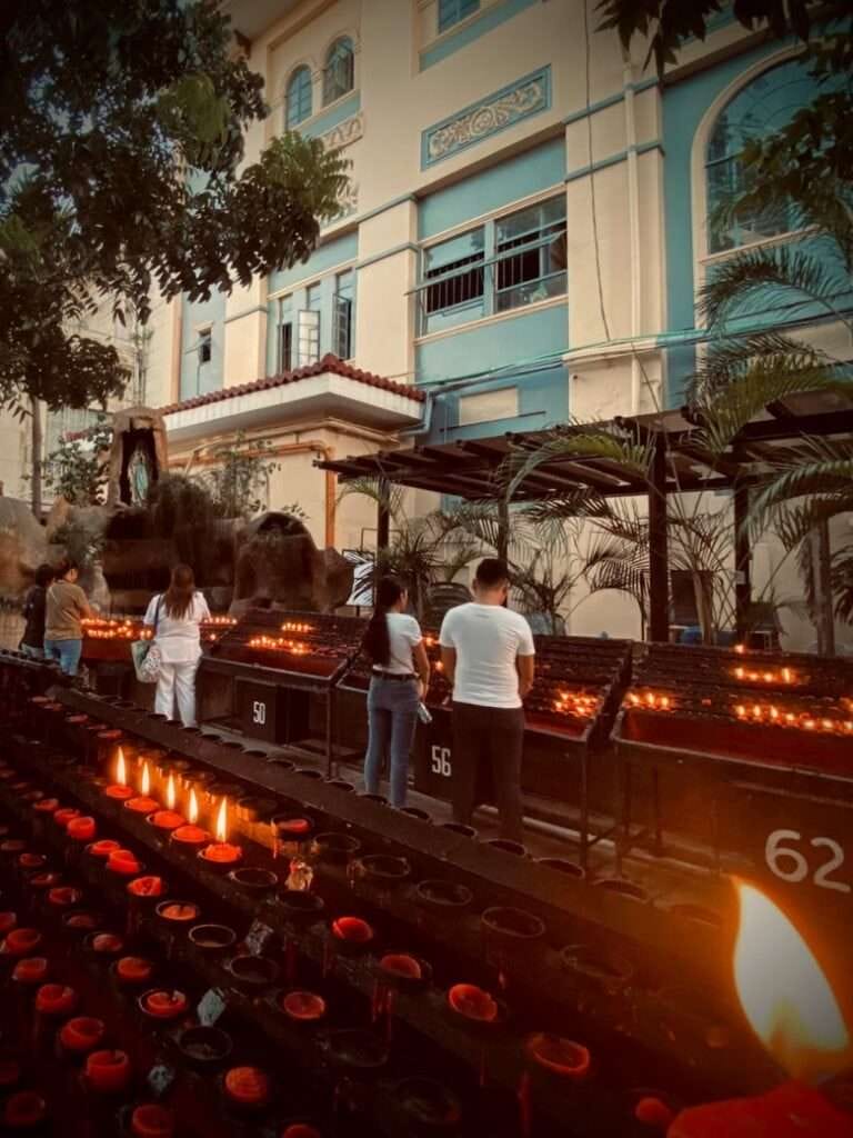 Visiting Basilica Minore del Santo Nino in Cebu City 5 People lighting red prayer candles outside the church