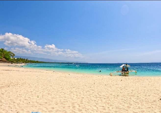 Moalboal Basdaku Beach: Beauty of Cebu's Coastal Gem 1 It is a picture of a beach in Moalboal, the tortuise color of the beach is a perfect match to the white sand. The boat on the shore also added the perfect scene.